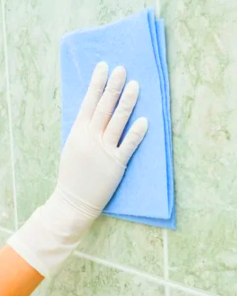 Sử dụng khăn sạch ẩm lau chùi bề mặt gạch lát nhà vệ sinh sau khi ốp lát xong